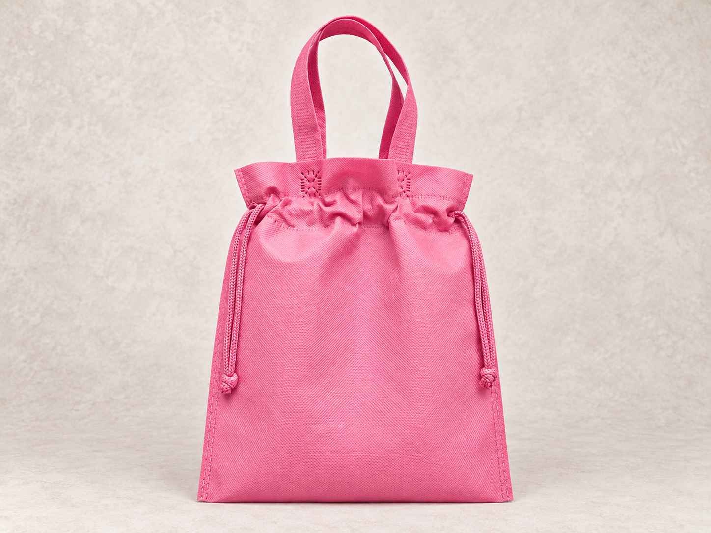  bolsa de cambrel reutilizable plana fusión rosada de pie vertical sobre una superficie neutra contra un fondo neutro.