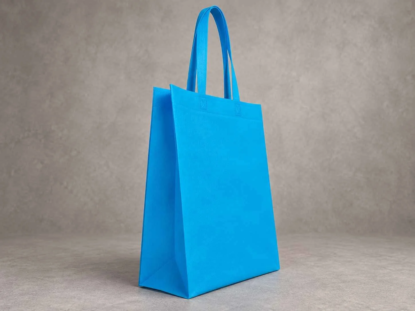 Bolsa 3 fuelles de cambrel reutilizable color azul bebé con manijas sobre un fondo neutro.
