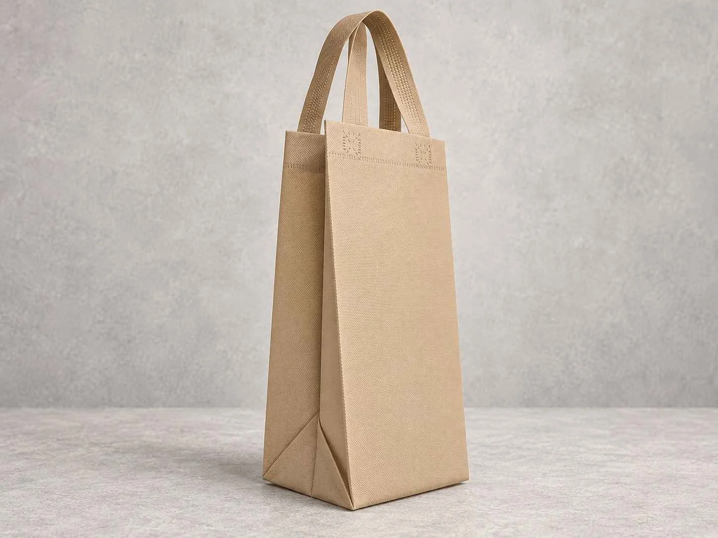 Beige paper shopping bag with handles on a light gray surface and background.