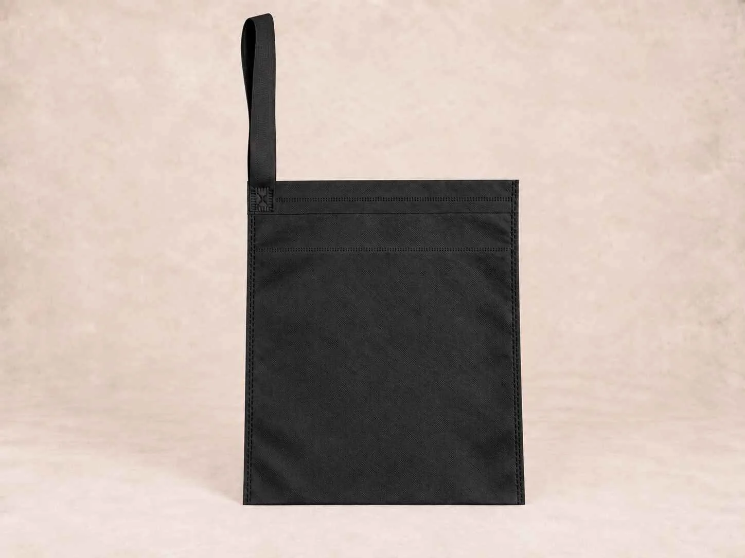  bolsa de cambrel reutilizable carro color negra de pie vertical sobre una superficie neutra contra un fondo neutro