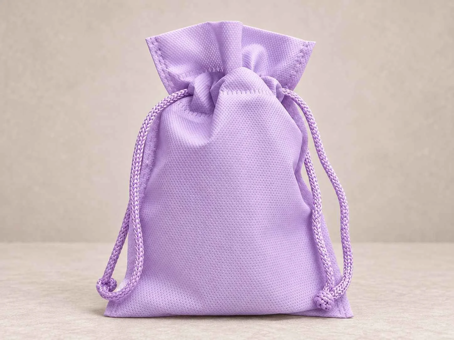 	
Bolsa de cambrel reutilizable caramelo con cordón color lila sobre un fondo neutro.