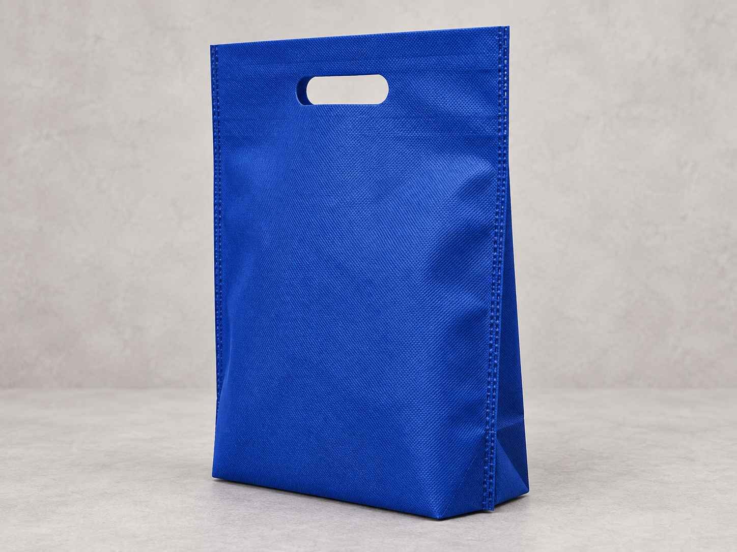 Bolsa plana troquel con fuelle abajo color azul  standing upright on a light-colored surface against a plain background.