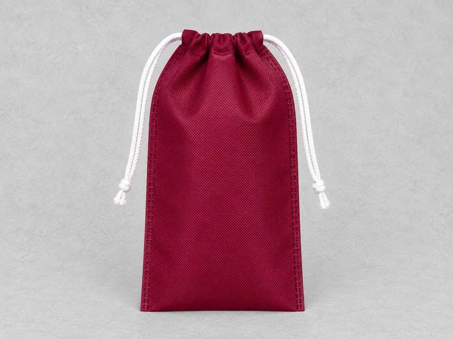 Red drawstring pouch with white cords on a light gray background