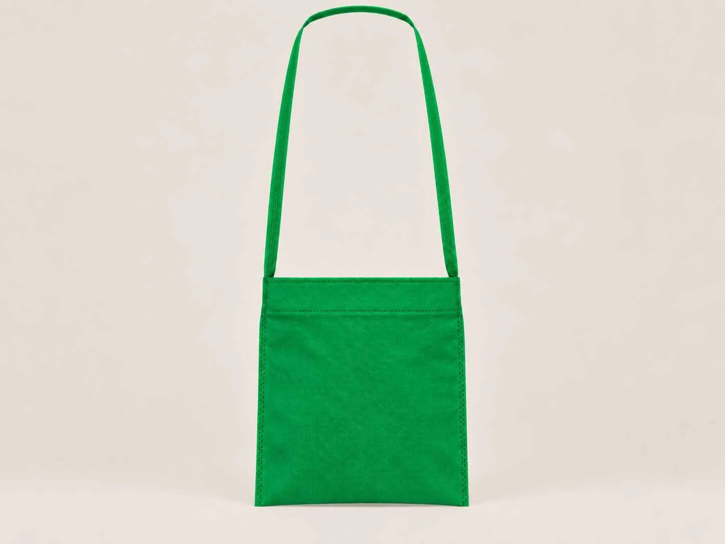 Bolsa de cambrel reutilizable manos libre color verde sobre un fondo neutro. 