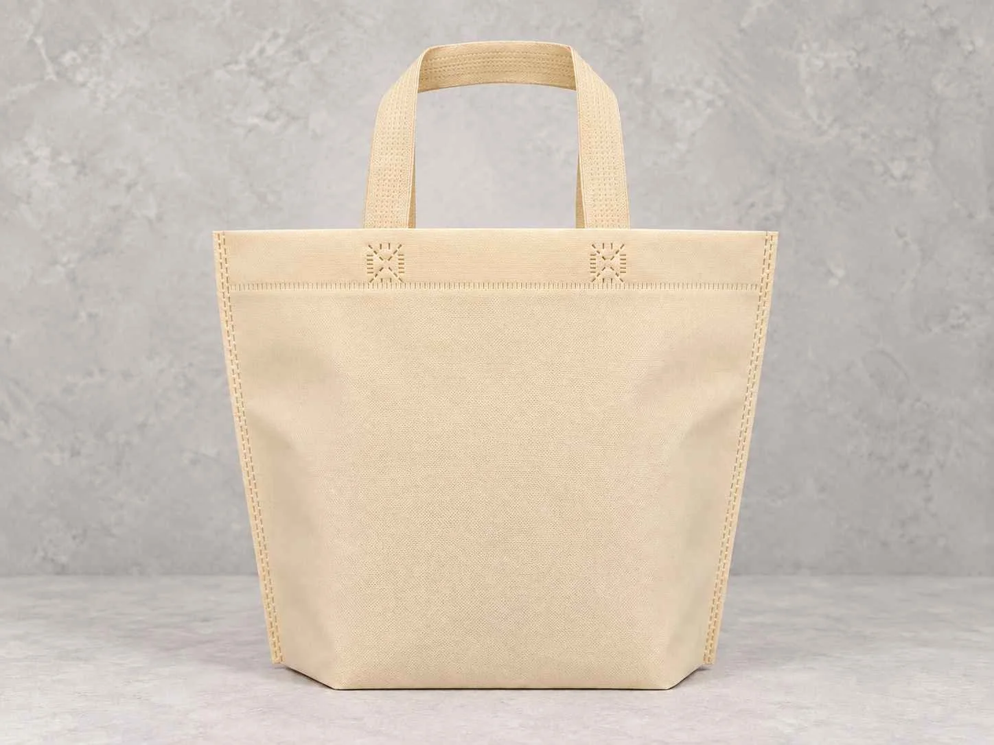 	
Bolsa de cambrel reutilizables manija plana con fuelle abajo color marfil sobre un fondo neutro.