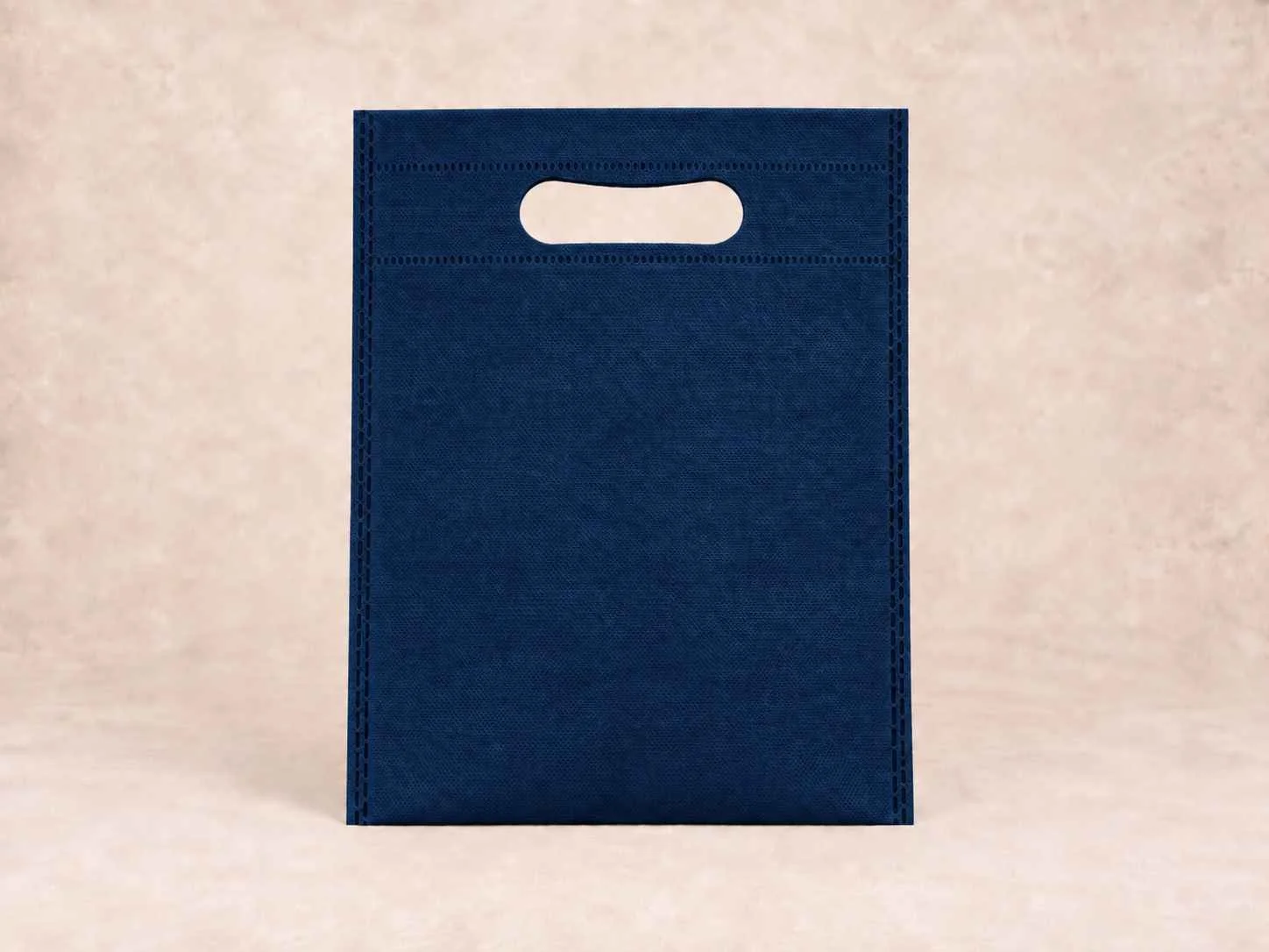Bolsa de cambrel reutilizable plana troquelada color azul oscura sobre un fondo neutro.