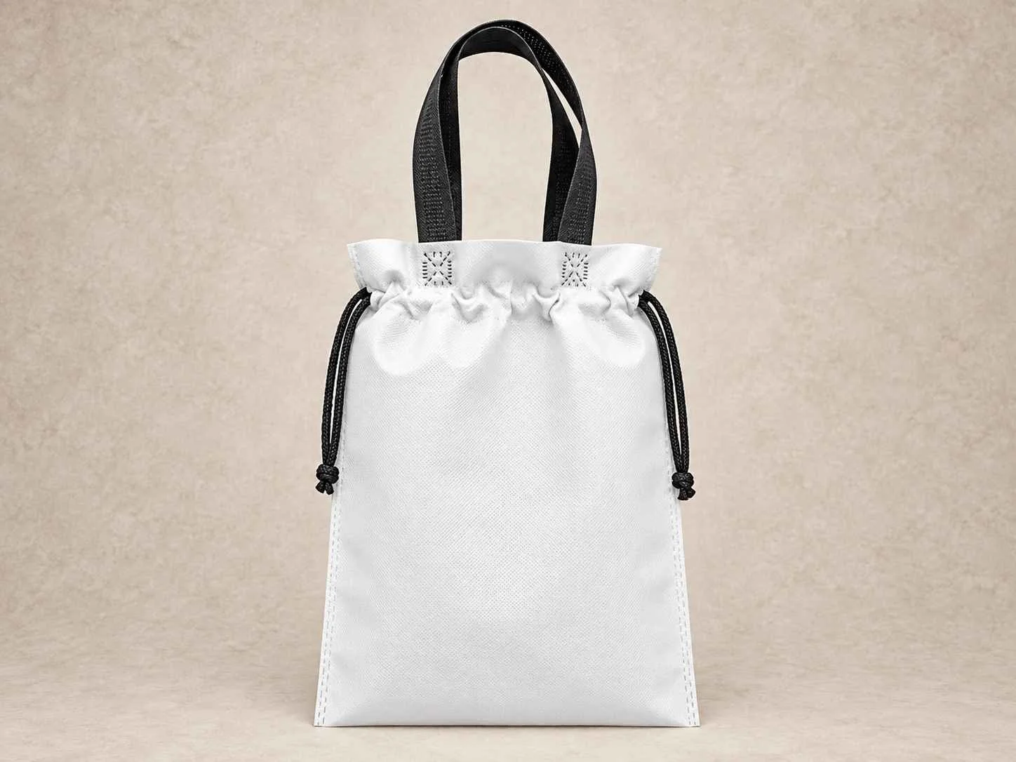  Bolsa de cambrel reutilizable plana fusión blanca con cordones negros  de pie vertical sobre una superficie neutra contra un fondo neutro.