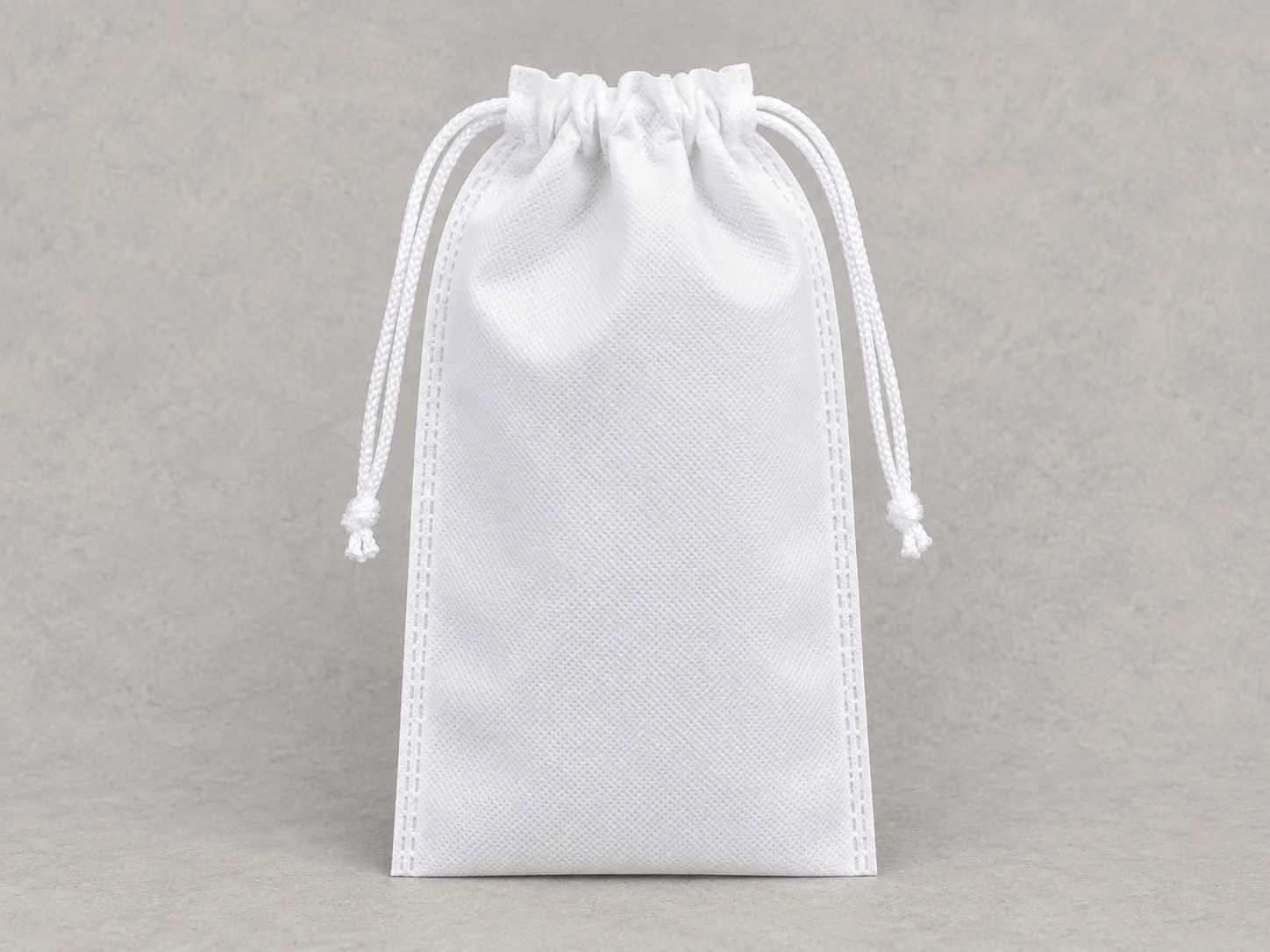 White drawstring pouch standing upright on a light gray background.