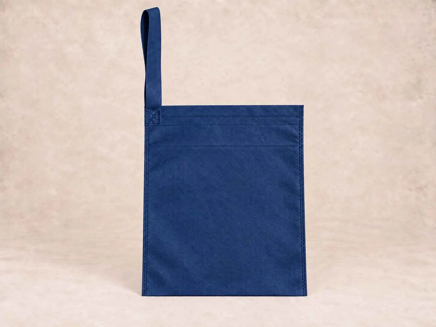  bolsa de cambrel reutilizable carro color azul oscura de pie vertical sobre una superficie neutra contra un fondo neutro.
