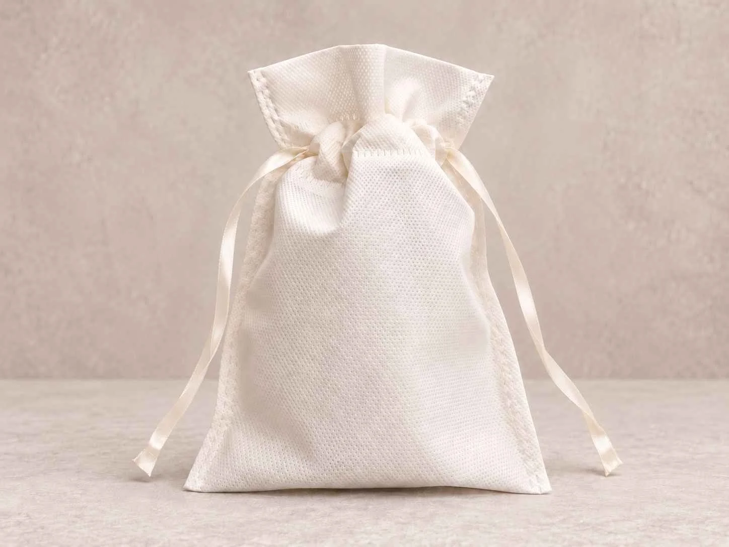 	
Bolsa de cambrel reutilizable caramelo color blanca con cinta sobre un fondo neutro.