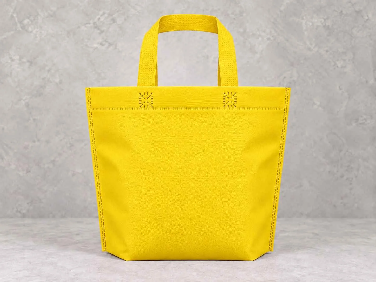 Bolsa de cambrel reutilizables plana manija con fuelle abajo color amarilla sobre un fondo neutro. 
