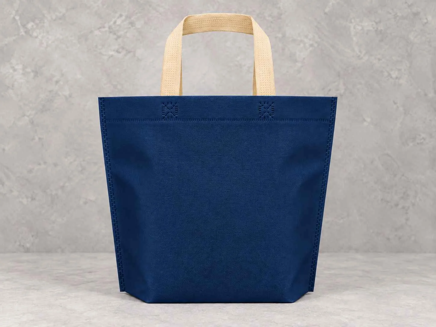 	
Bolsa de cambrel reutilizables manija plana con fuelle abajo color azul oscuro con manijas beige sobre un fondo neutro..
