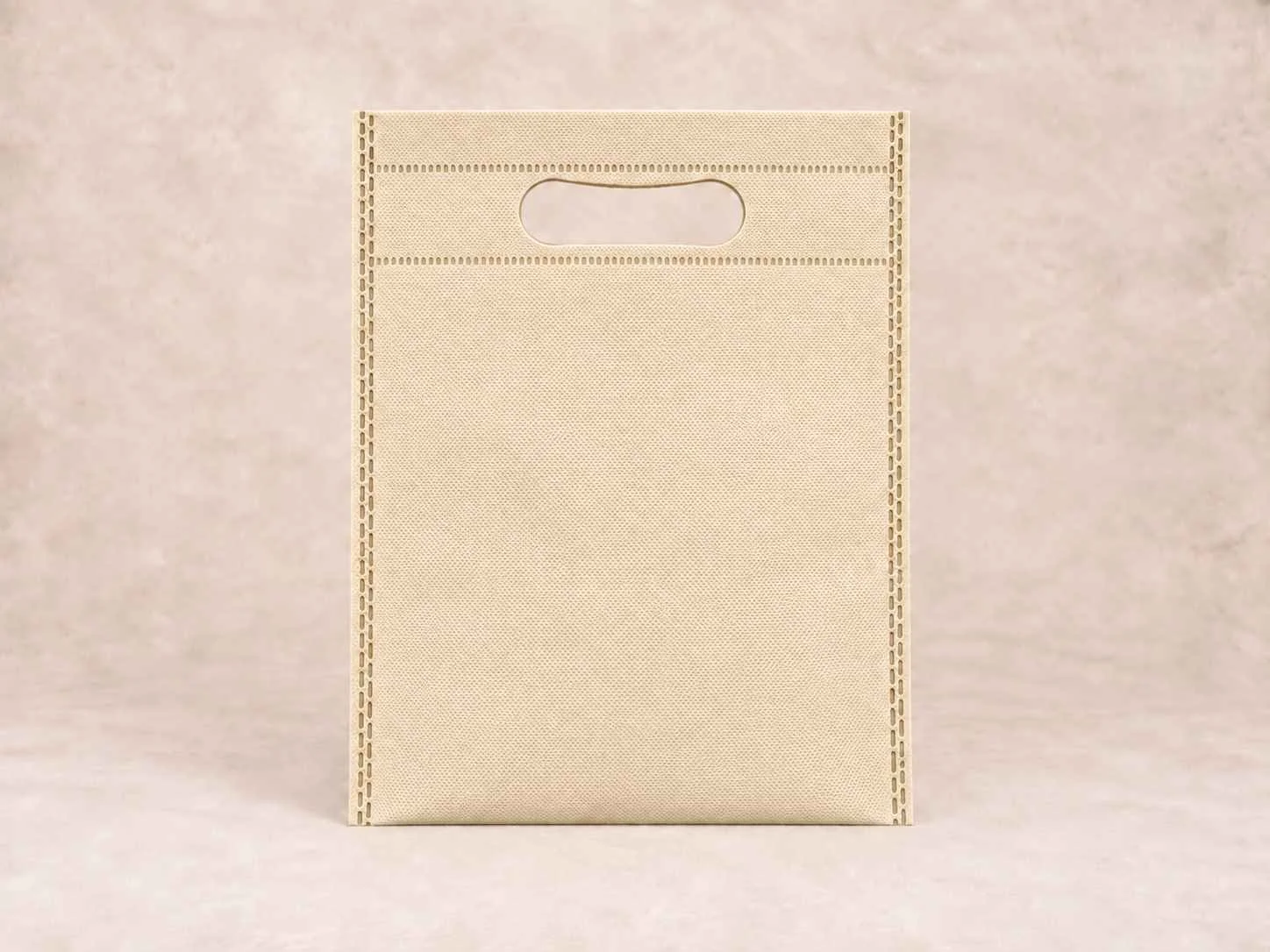 Bolsa de cambrel reutilizable plana troquelada color beige sobre un fondo neutro.