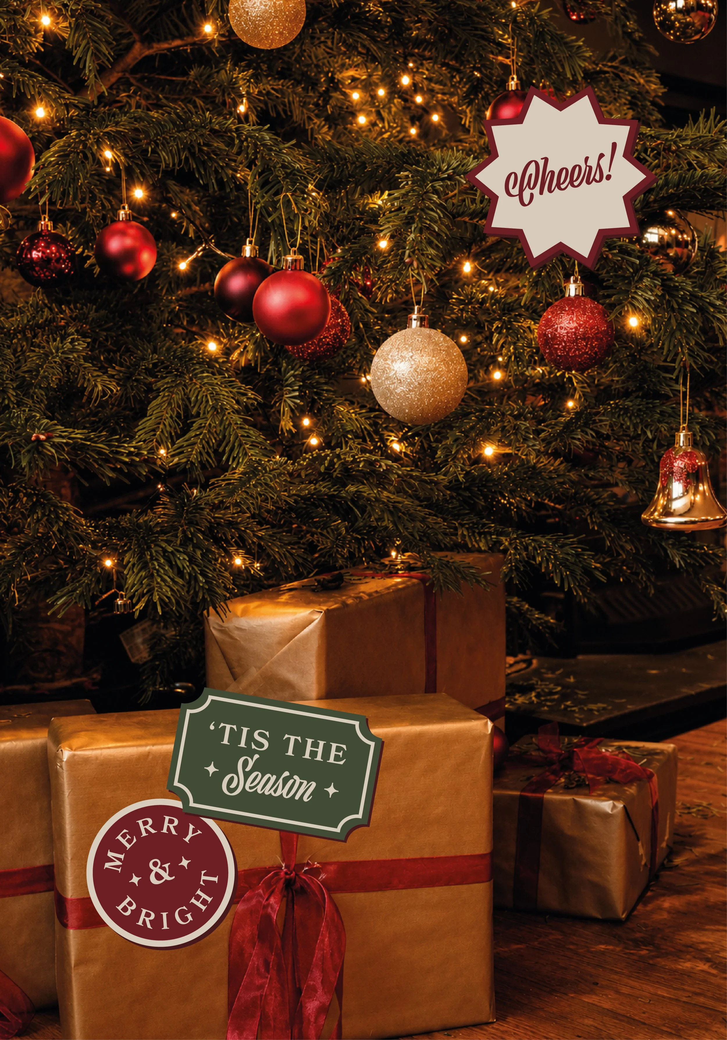 Decorated Christmas tree with red and gold ornaments and warm lights, with wrapped presents underneath, and a festive sign that reads 'Tis the Season' in front.