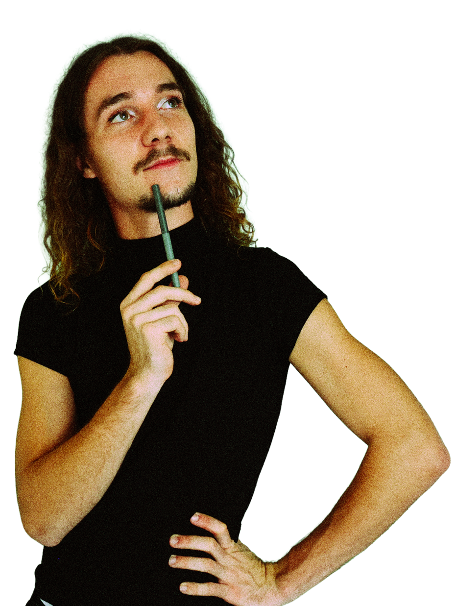 Jeune homme avec long cheveux, barbe et moustache, portant un t-shirt noir, tenant un stylo à la bouche, pensif.
