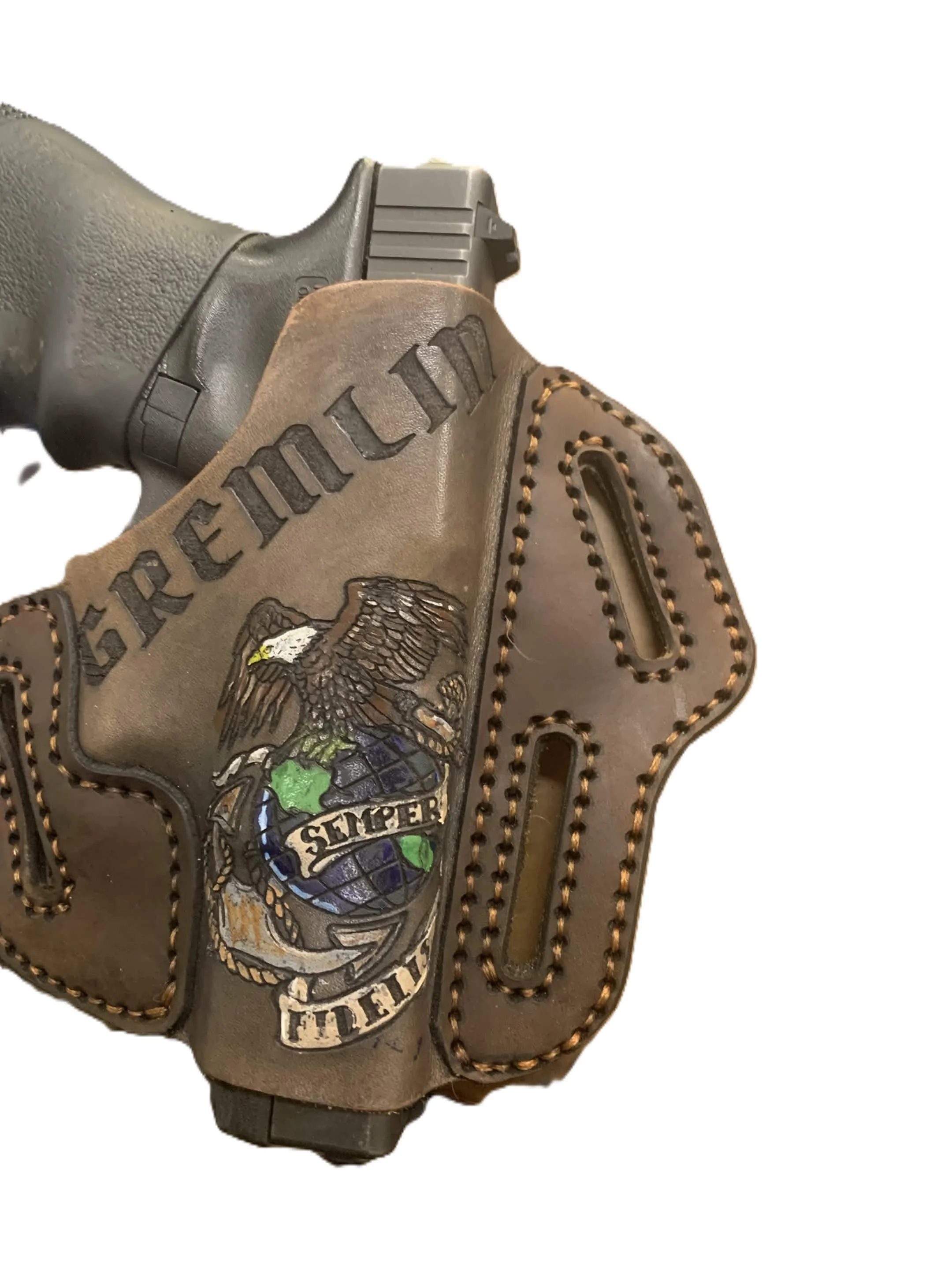 Close-up of a gun holster with a handgun partially visible inside, featuring military or combat-themed patches and designs.