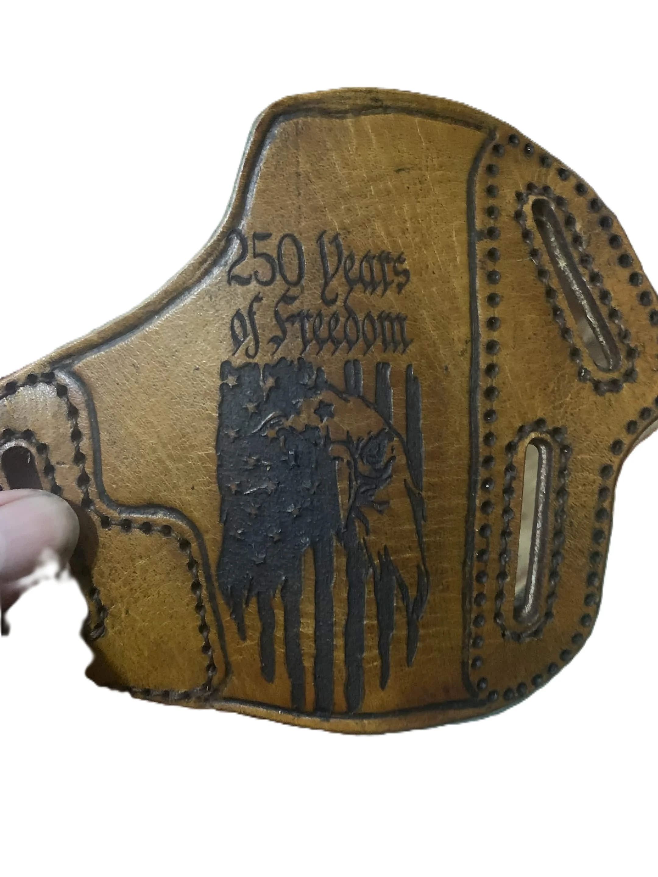 Close-up of a leather holster with black printed text that reads "250 Years of Freedom" and a black illustration of a tree.