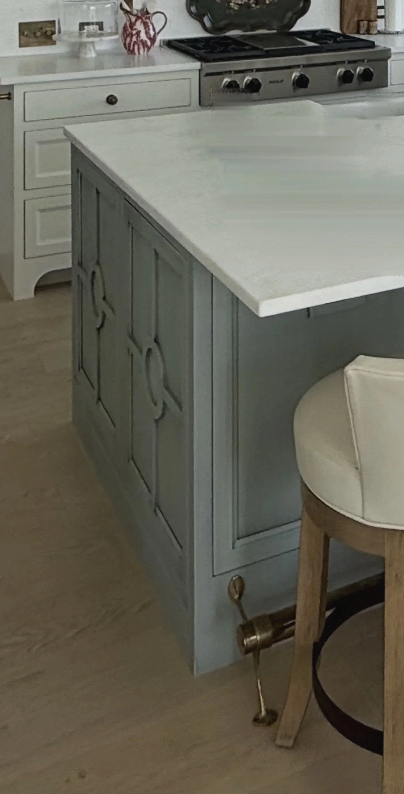 Custom kitchen cabinetry with sage green base cabinets, white stone countertop, and integrated storage by Rift & Quarter