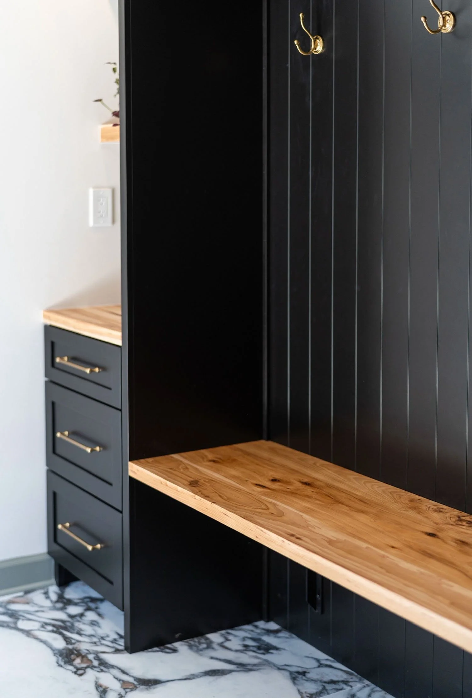 Custom black built-in cabinetry with wood bench seat and integrated storage by Rift & Quarter in Central Virginia