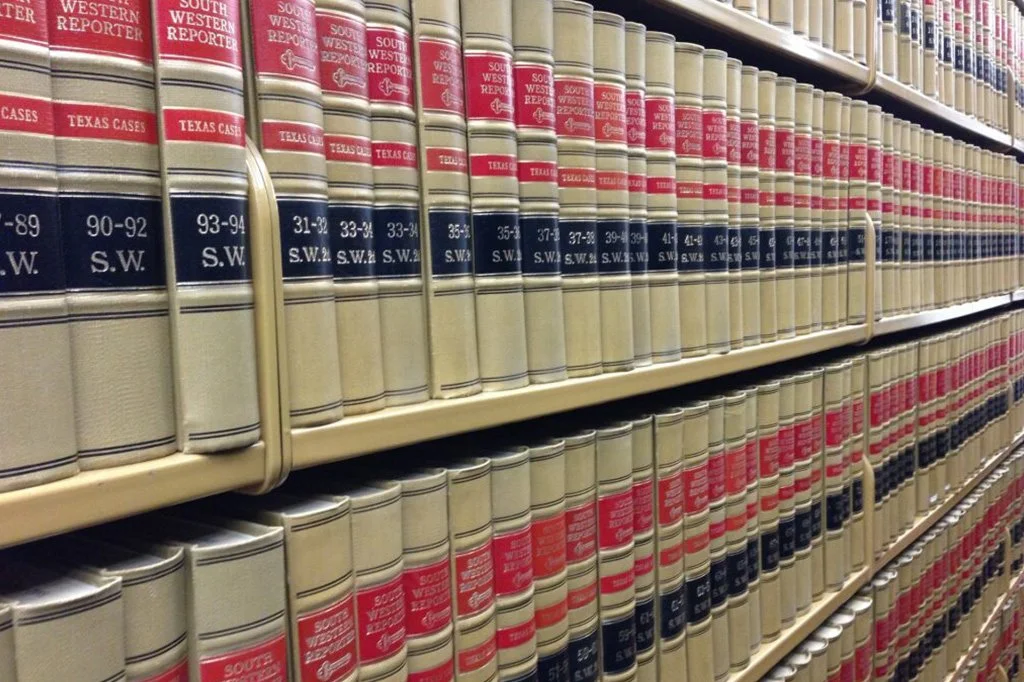 Bookshelves filled with legal reference books, titled 'South Western Reporter' and 'Texas Cases'.