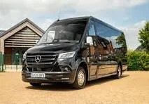 Black Mercedes-Benz Sprinter van parked outside a chalet-style building