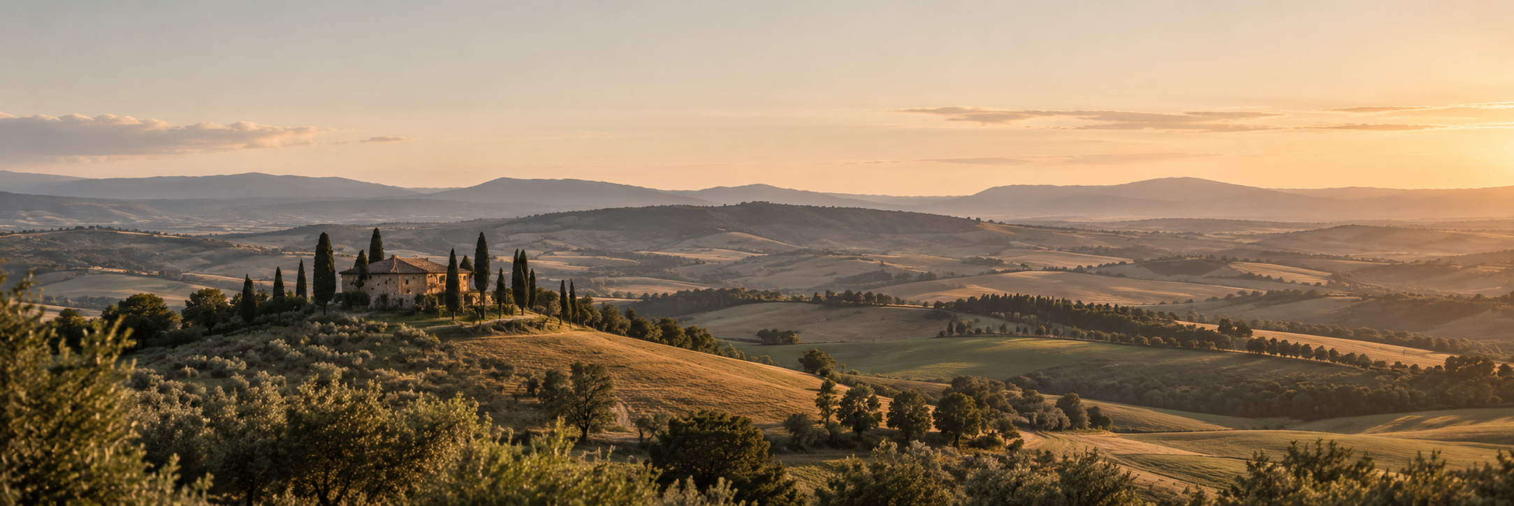 Paysage avec collines, champs et une maison entourée d'arbres, au coucher du soleil.