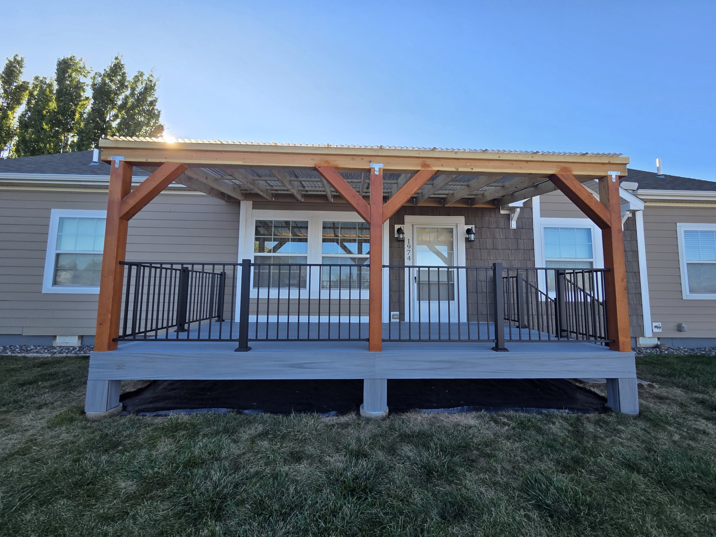 	
Custom backyard deck with black metal railing and pergola in Logan, Utah