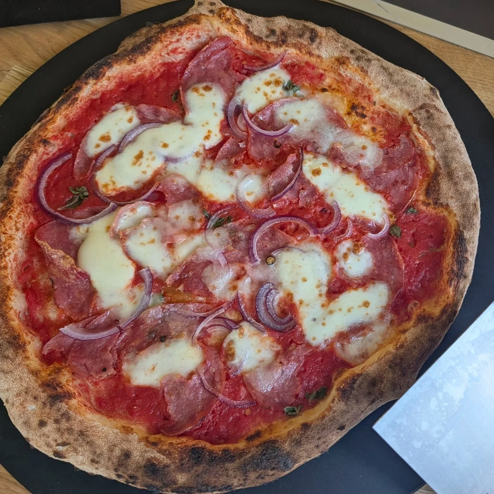 Pizza Salame Napoli - mit Tomatensauce, Mozzarella, Salami, roten Zwiebeln.