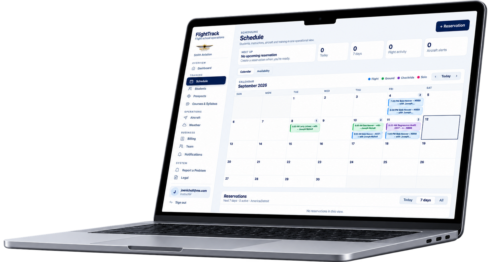 Laptop screen displaying flight school operations scheduling software with a calendar view of September 2026, including flight training events, and a sidebar menu with options like dashboard, students, aircraft, and business.