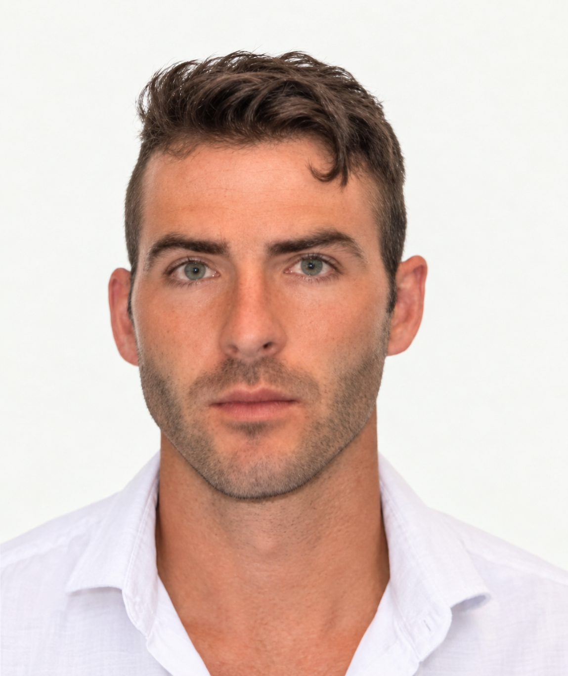 Close-up portrait of a young man with short brown hair, blue eyes, wearing a white shirt, against a plain white background.