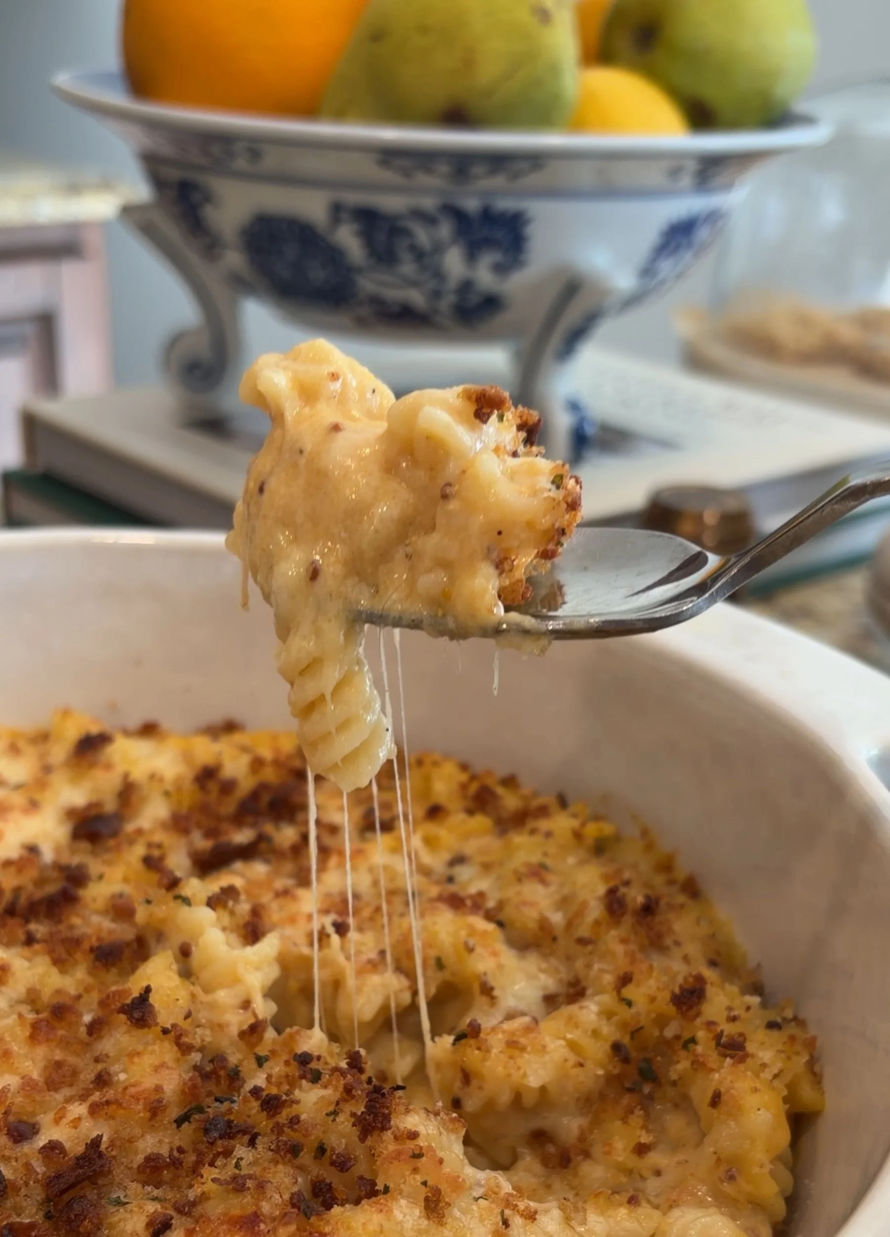 Cheesy pumpkin mac and cheese with nutmeg and old-style mustard, served warm with a gooey cheese pull.