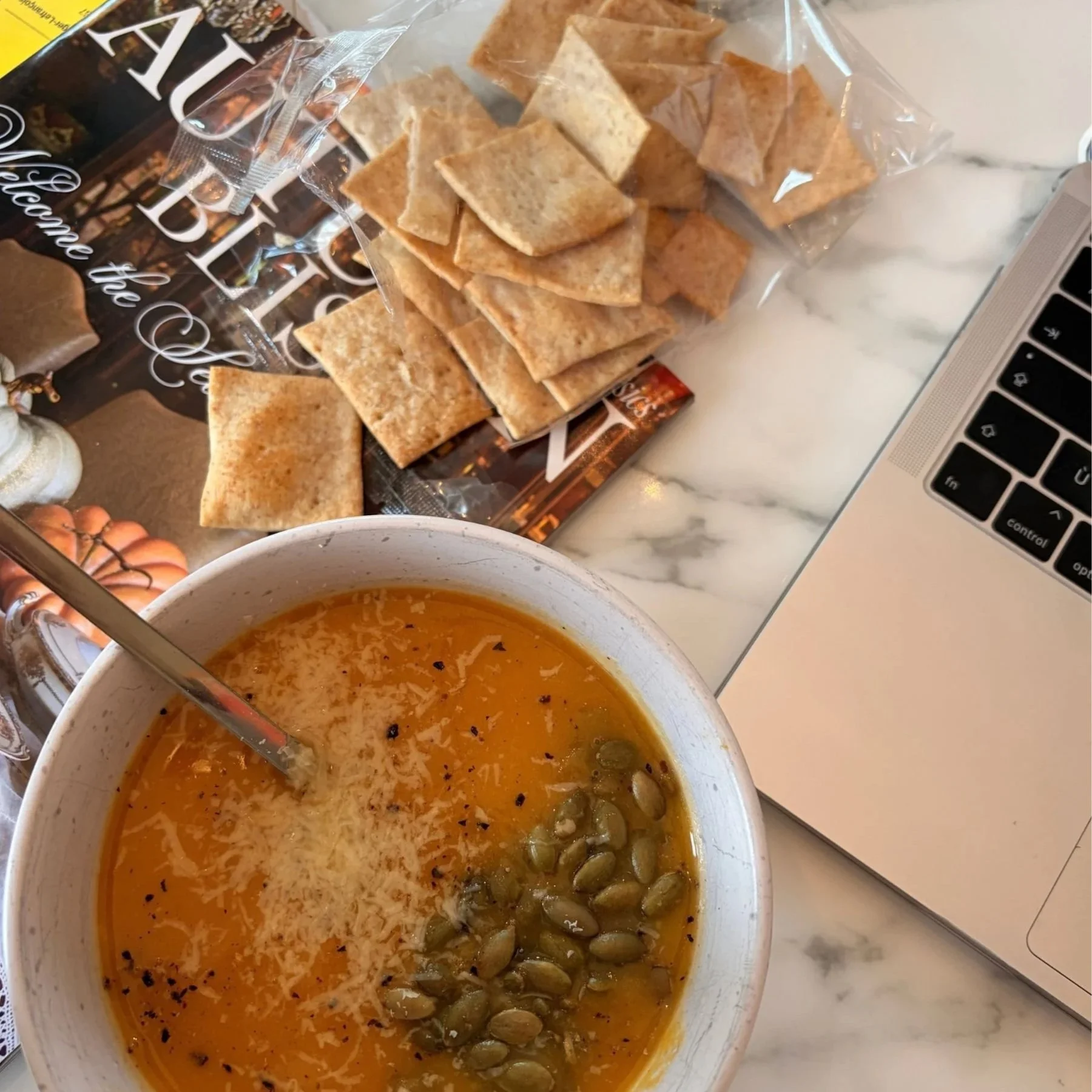 Butternut squash soup topped with pumpkin seeds, Parmesan and freshly cracked pepper with crackers on the side