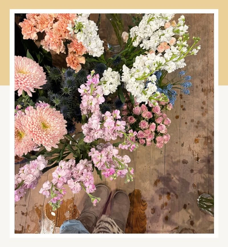 Fresh seasonal garden flowers arranged on a rustic wooden table.