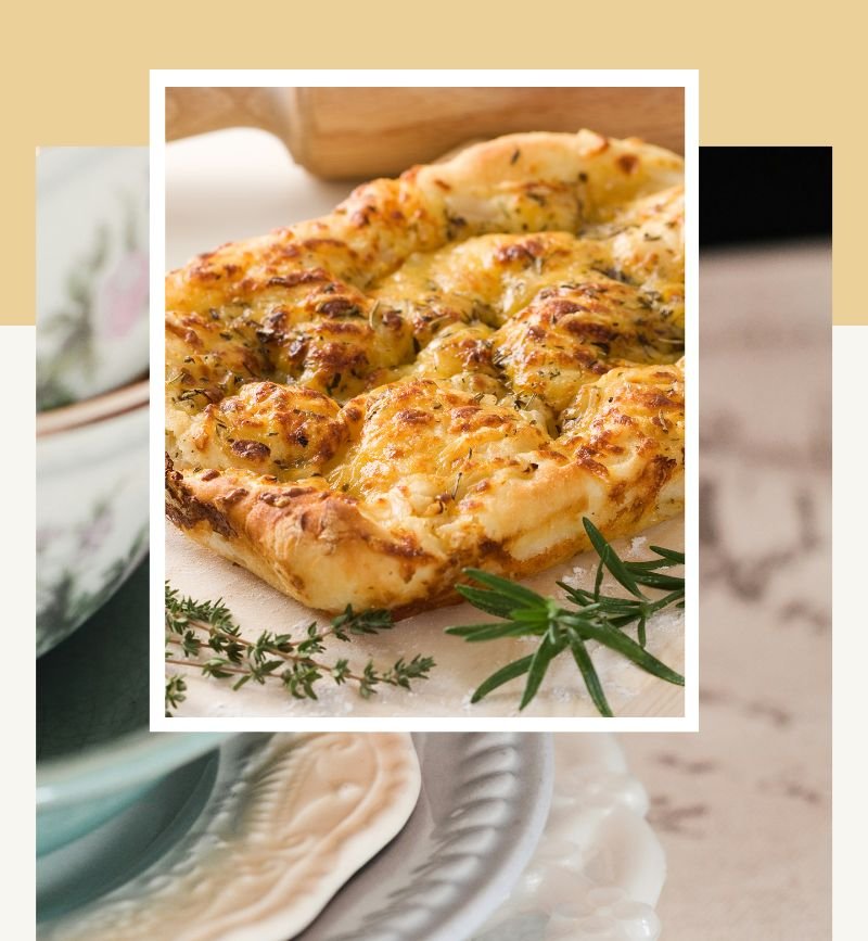Homemade rosemary focaccia served with simple white dinnerware.