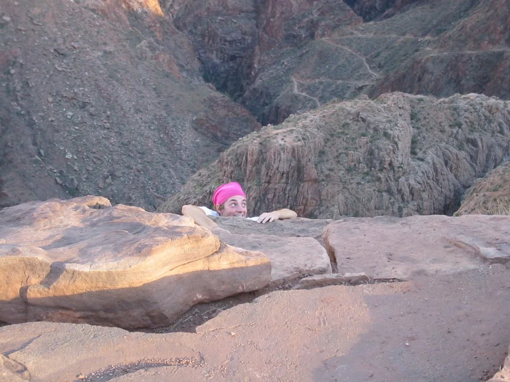 Young women, early 20s, pretending to fall off a cliff in the Grand Canyon, Arizona, in 2003