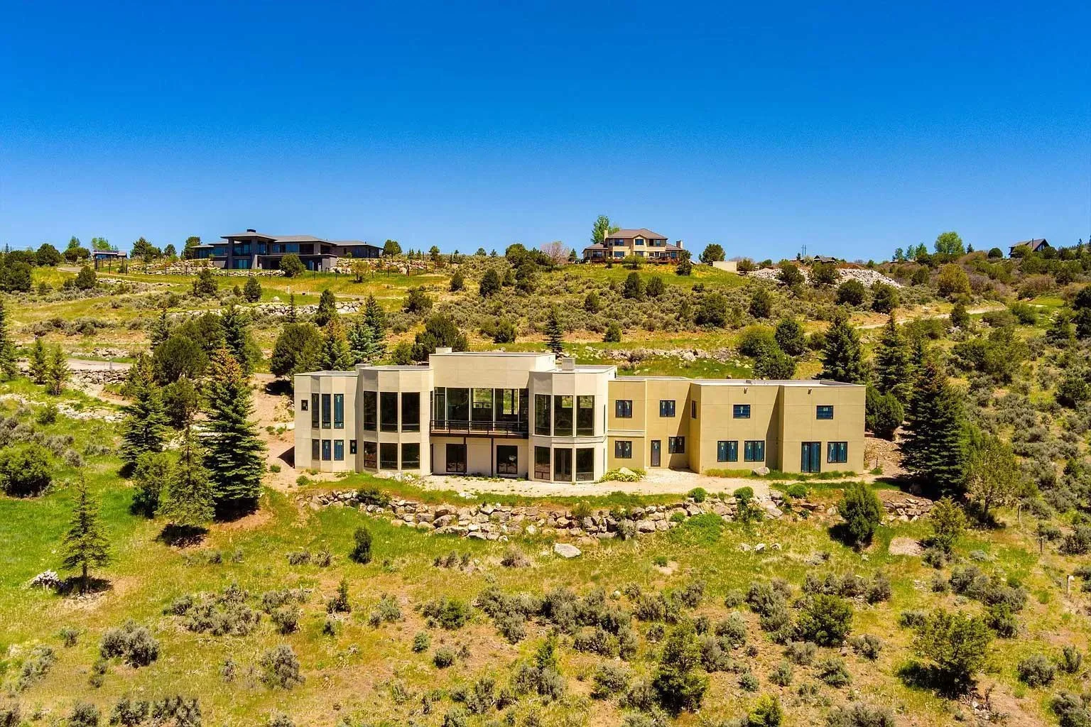 Rear view of a modern, partially finished home in the mountains built by Form 44 Construction surrounded by forest