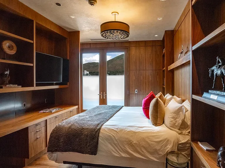Elegant guest suite surrounded by custom wood built-ins and modern light fixtures at The Mother Lode in Aspen, Colorado.