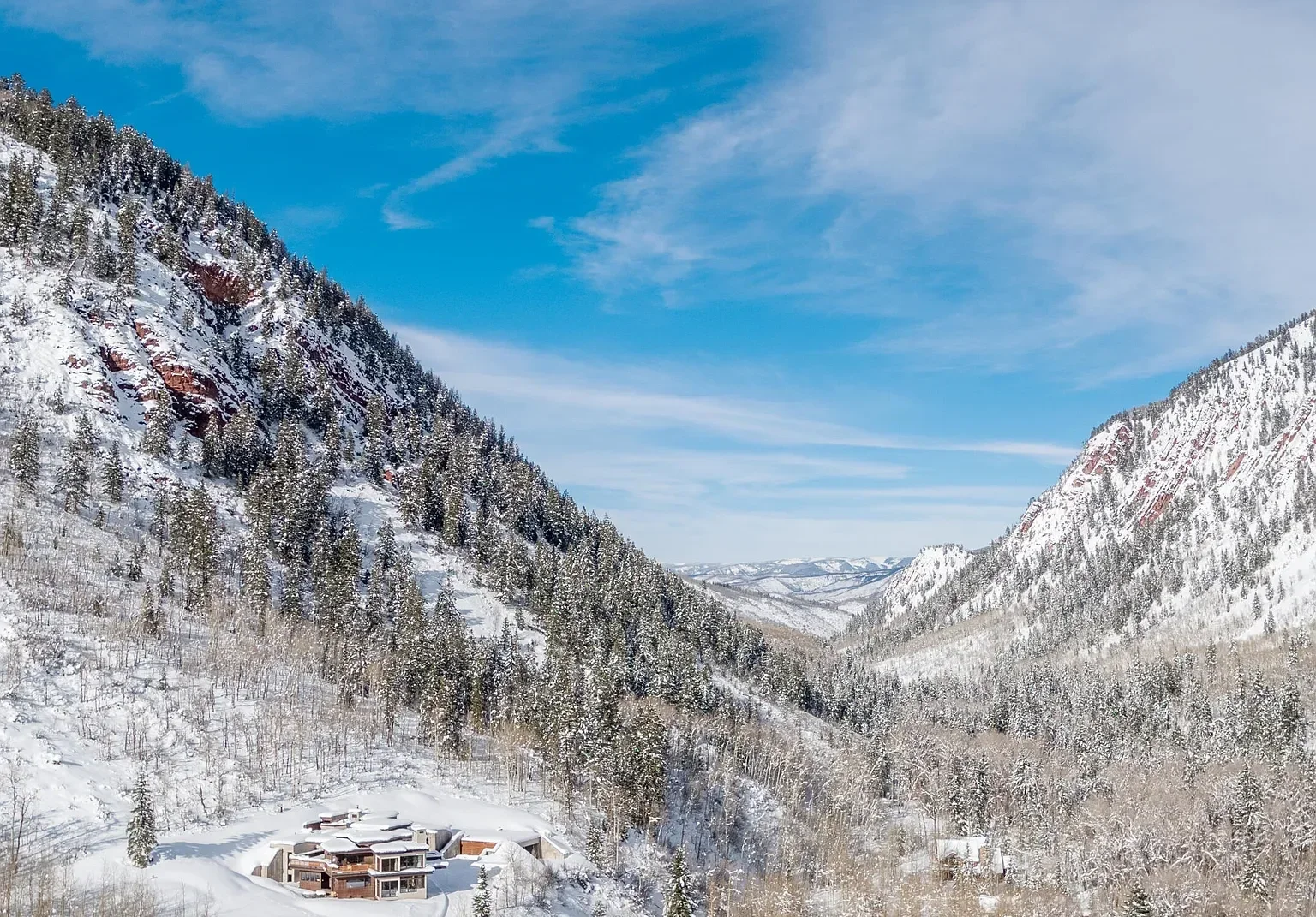 Mountain view of modern residential home with terraced lawn nestled in the mountains built by Form 44 Construction near Conundrum Creek in Aspen, CO