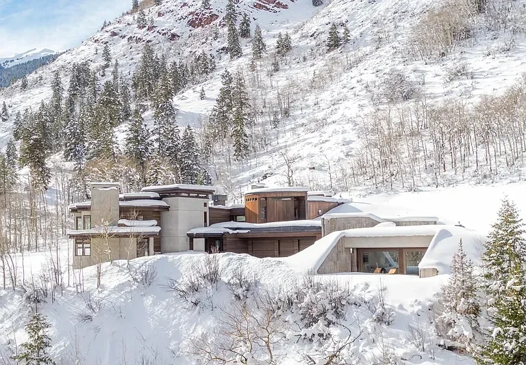 Snowy modern residential home with terraced lawn nestled in the mountains built by Form 44 Construction near Conundrum Creek in Aspen, CO