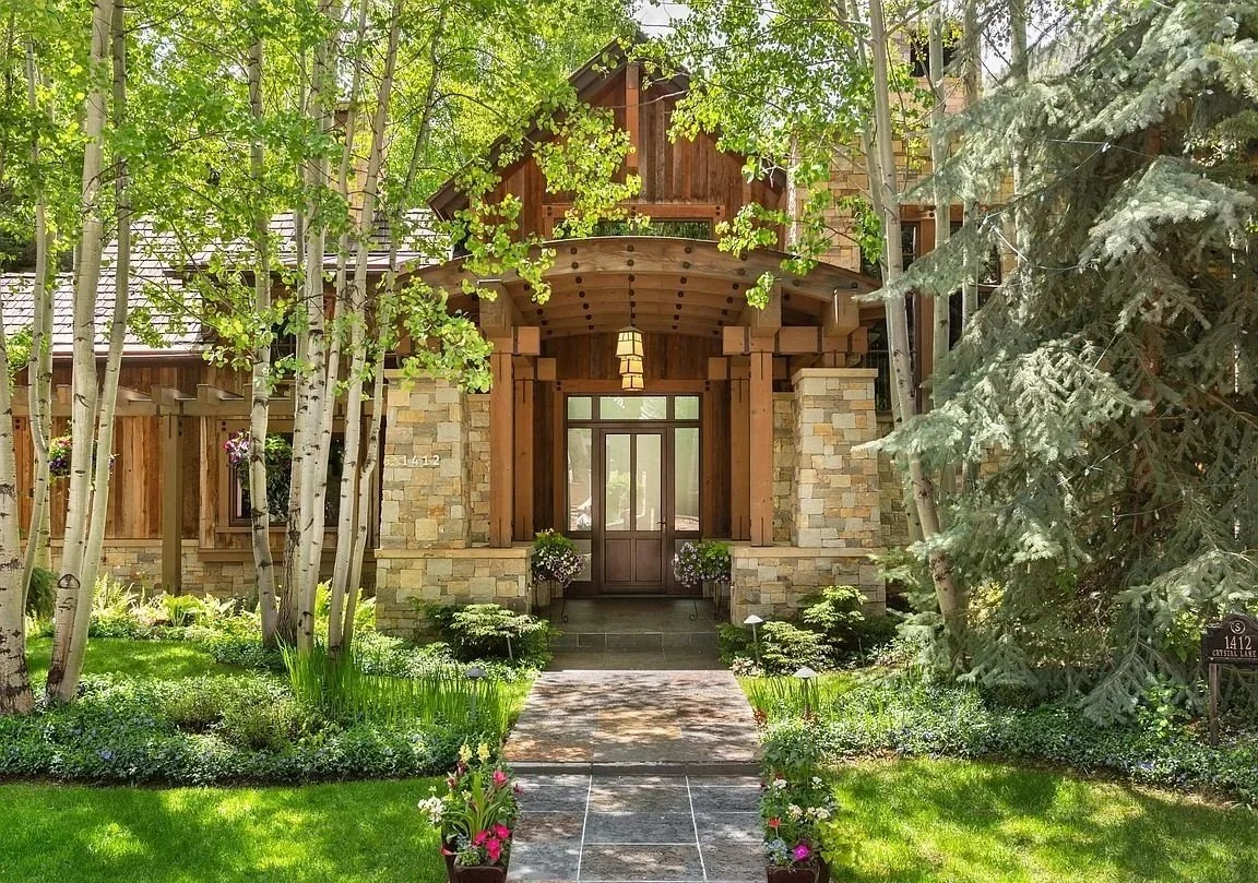 Entryway of an elegant stone and wood home in the mountains with large surrounded by trees and wildflowers built by John Olson, owner of Form 44 Construction, on Crystal Lake Road in Aspen, Colorado 