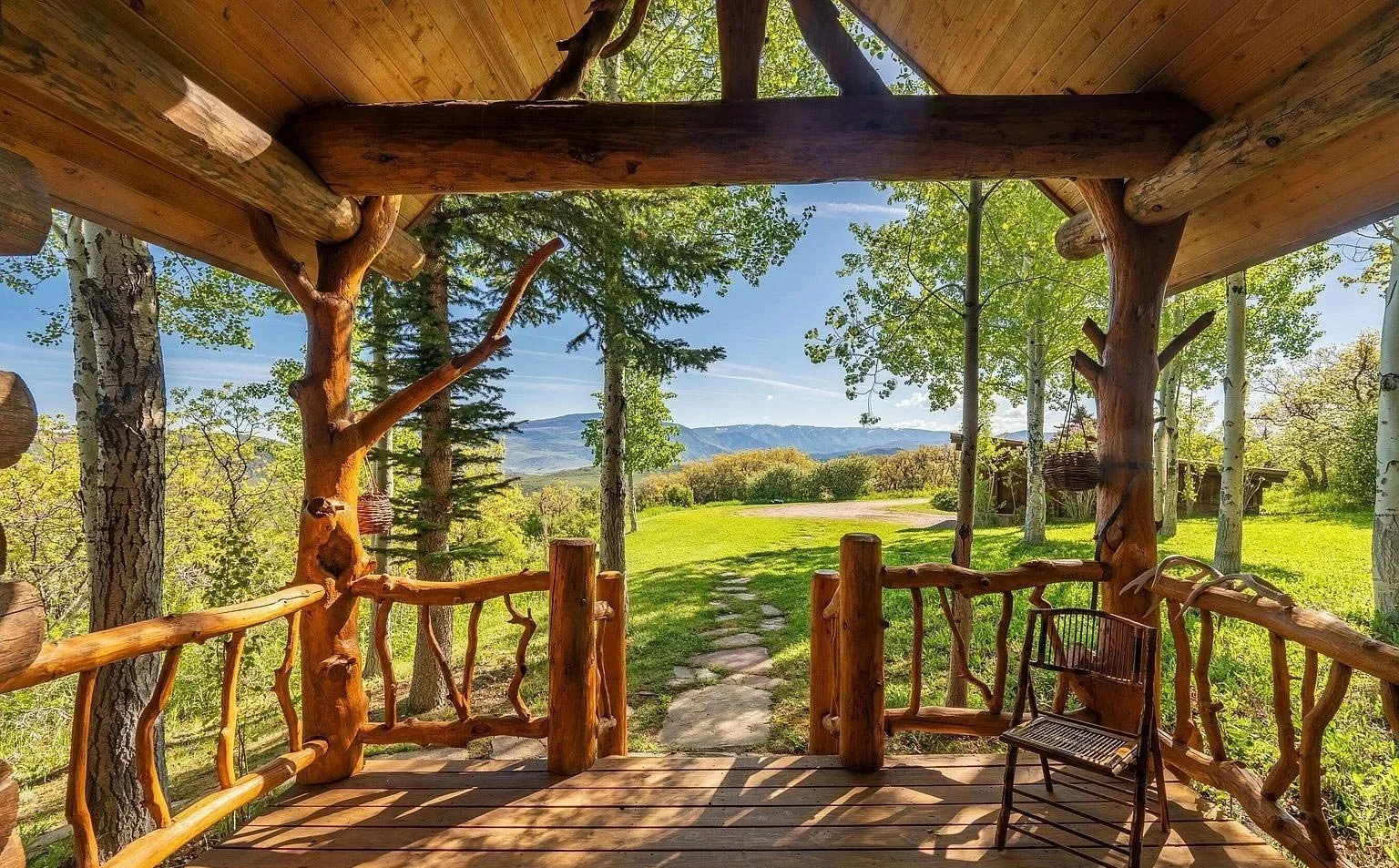 A scenic porch with a natural wooden railing overlooking majestic mountains built by John Olson, owner of Form 44 Construction, on Old Herron Road in Basalt, Colorado.