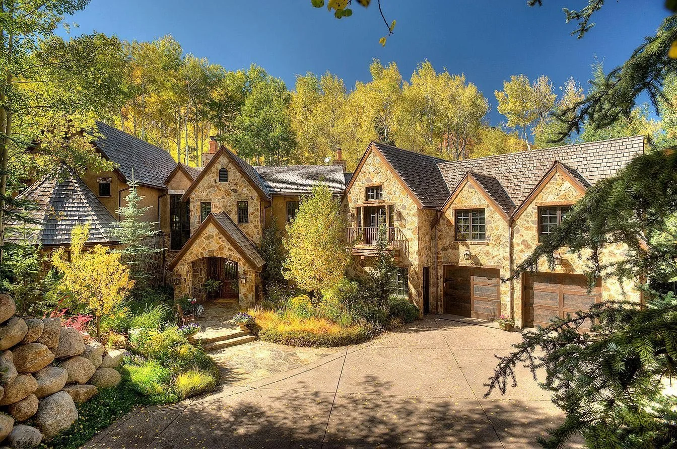 A picturesque, spacious stone house nestled amidst lush golden aspen trees built by John Olson, owner of Form 44 Construction, on Spruce Ridge Lane in Snowmass Village, Colorado.