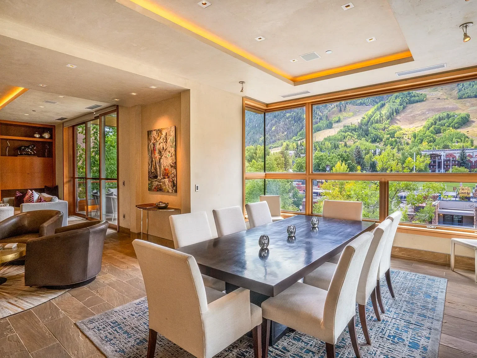 Modern luxury formal dining area featuring floor-to-ceiling corner windows with views of Aspen Mountain at The Mother Lode in Aspen, Colorado.