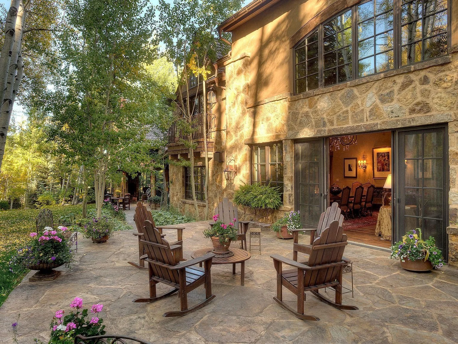 Serene flagstone patio and natural stone masonry exterior on a luxury home with large sliding glass patio doors built by John Olson, owner of Form 44 Construction, on Spruce Ridge Lane in Snowmass Village, Colorado.