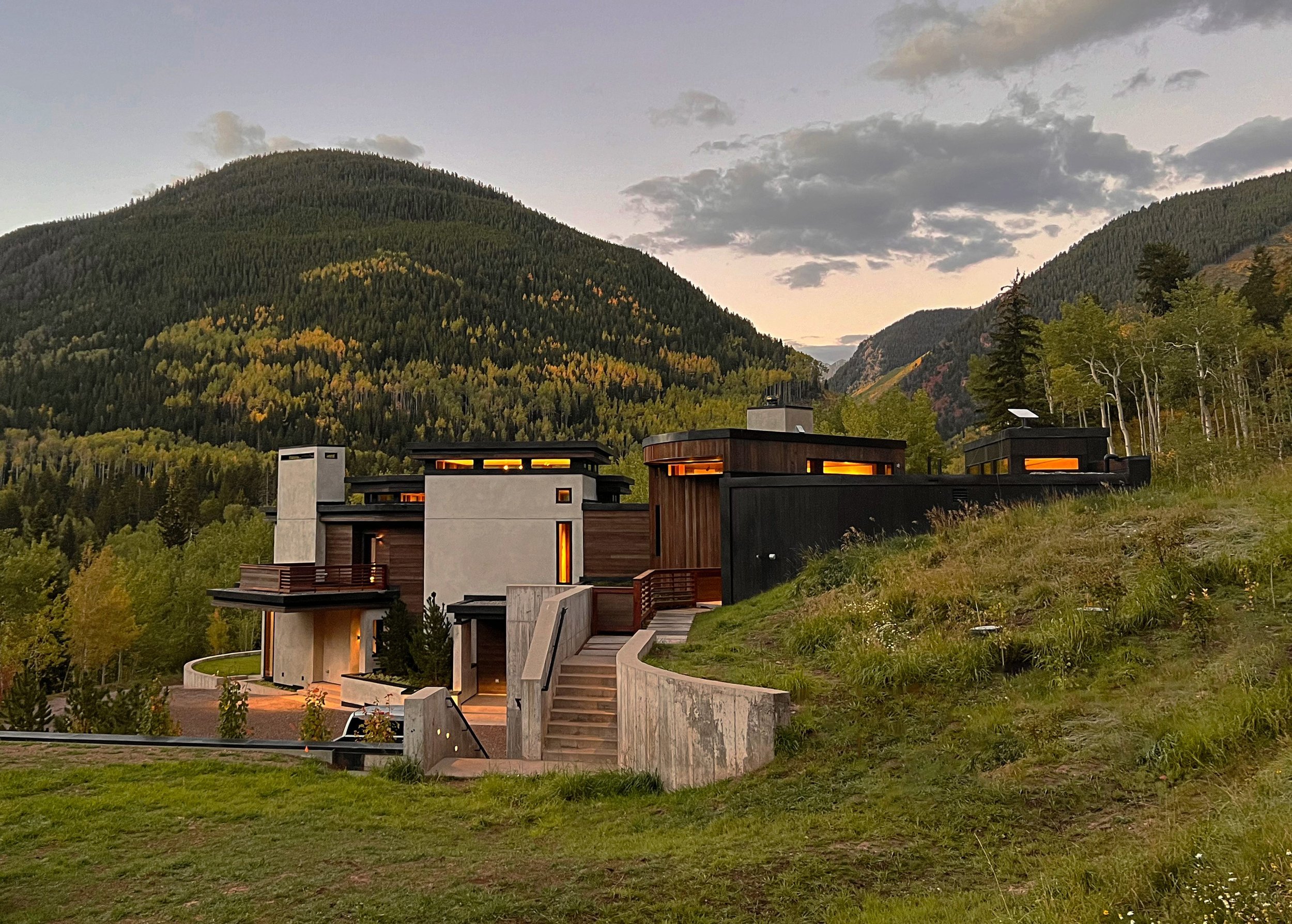 Side view of a modern residential home with terraced lawn nestled in the mountains built by Form 44 Construction near Conundrum Creek in Aspen, CO