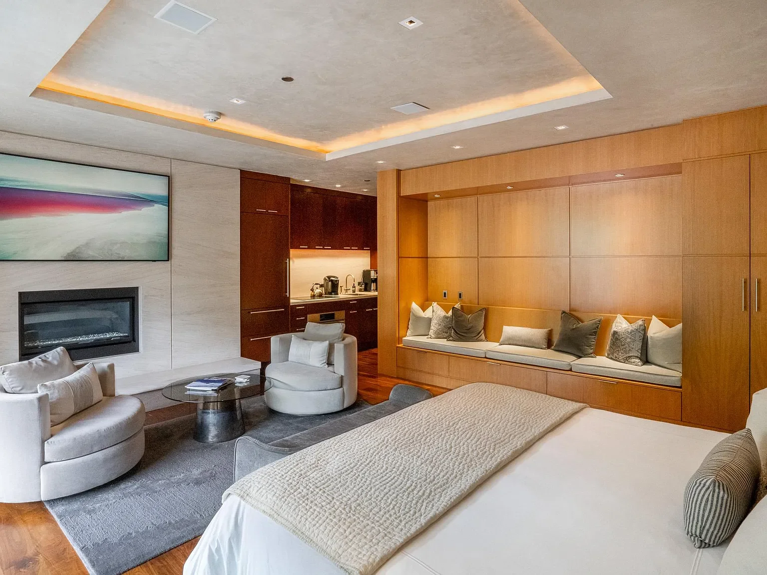 Luxury spacious master suite with linear fireplace, seating lounge, and built-in wet bar at The Mother Lode in Aspen, Colorado.