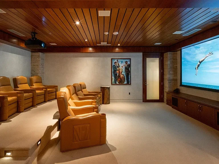 Luxury home theater room with leather reclining seats and wood slat ceiling at The Mother Lode in Aspen, Colorado.
