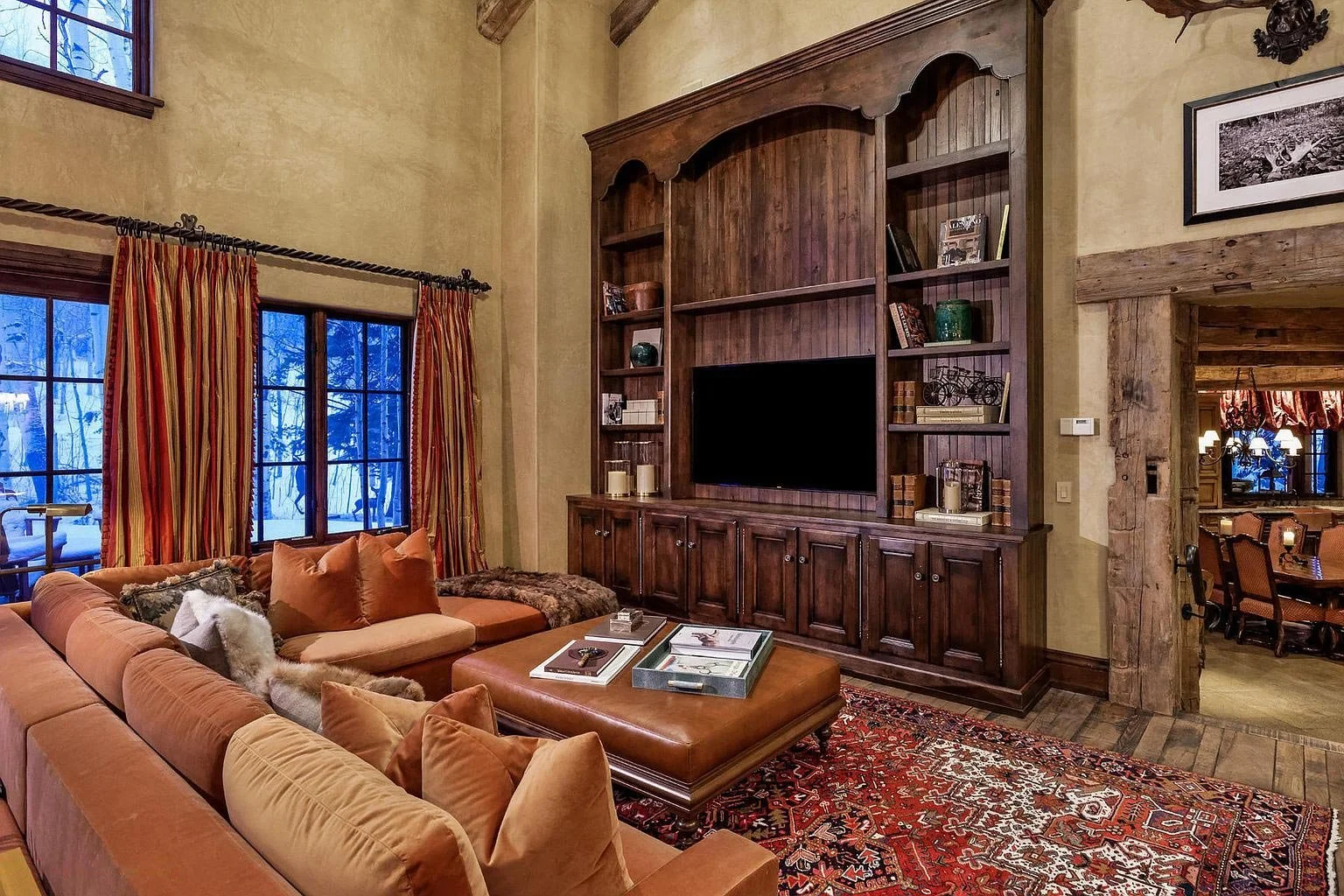 A spacious modern mountain style living room with an expansive custom entertainment center built by John Olson, owner of Form 44 Construction, on Spruce Ridge Lane in Snowmass Village, Colorado.