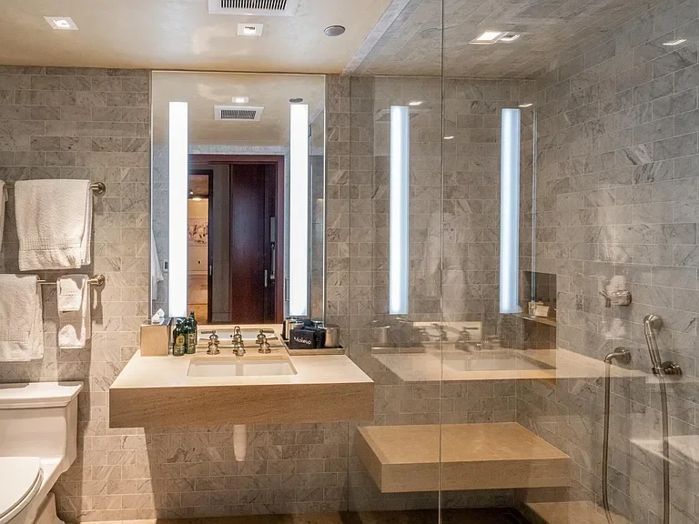 Luxury modern marble bathroom featuring floating stone vanity and glass walk-in shower at The Mother Lode in Aspen, Colorado.