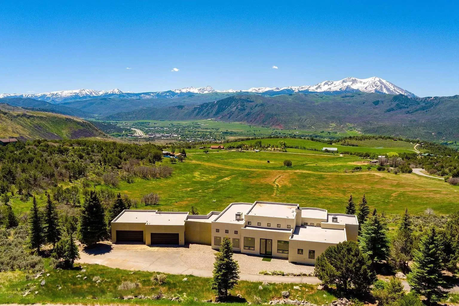 Front view of a modern, partially finished home in the mountains built by Form 44 Construction surrounded by forest